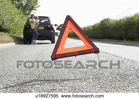 Mother And Daughter Broken Down On Country Road With Hazard Warning Sign In Foreground View Large Photo Image Stock Photography - Mother And Daughter Broken Down On Country Road With Hazard Warning Sign In Foreground. Fotosearch