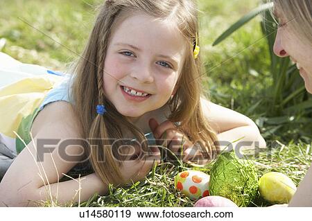 Stock Photo - Mother And Daughter On Easter Egg Hunt In Daffodil Field. Fotosearch