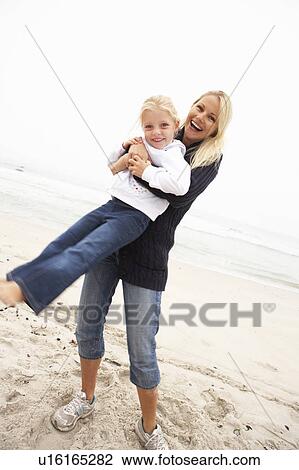 Stock Image - Mother And Daughter On Holiday Having Fun On Winter Beach. Fotosearch