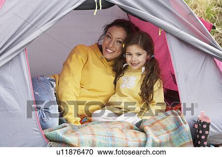 Stock Image - Mother And Daughter Relaxing Inside Tent On Camping Holiday. Fotosearch