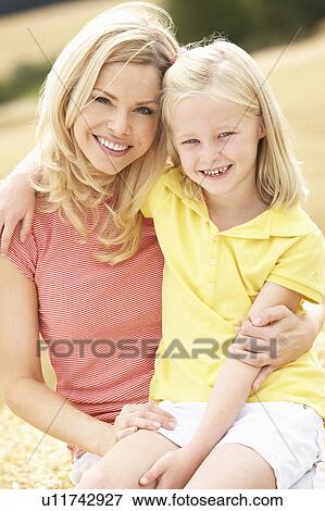 Mother And Daughter Sitting On Straw Bales In Harvested Field View Large Photo Image Stock Photo - Mother And Daughter Sitting On Straw Bales In Harvested Field. Fotosearch