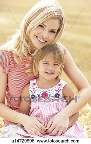Mother And Daughter Sitting On Straw Bales In Harvested Field View Large Photo Image Stock Photograph - Mother And Daughter Sitting On Straw Bales In Harvested Field. Fotosearch