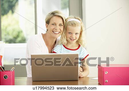 Stock Image - Mother And Daughter Using Laptop At Home. Fotosearch