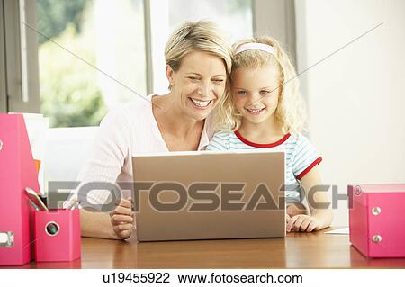 Stock Image - Mother And Daughter Using Laptop At Home. Fotosearch