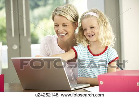 Stock Photograph - Mother And Daughter Using Laptop At Home. Fotosearch