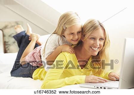 Mother And Daughter Using Laptop Relaxing Sitting On Sofa At Home View Large Photo Image Stock Image - Mother And Daughter Using Laptop Relaxing Sitting On Sofa At Home. Fotosearch