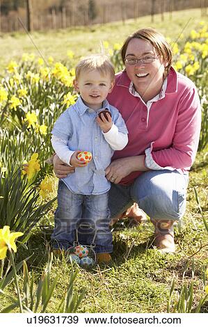 Stock Photo - Mother And Son On Easter Egg Hunt In Daffodil Field. Fotosearch