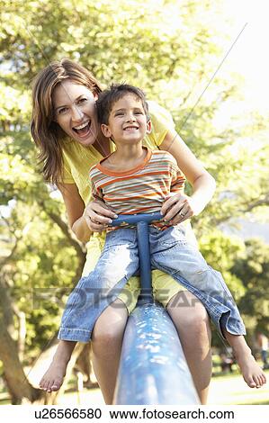 Stock Image - Mother And Son Riding On See Saw In Playground. Fotosearch