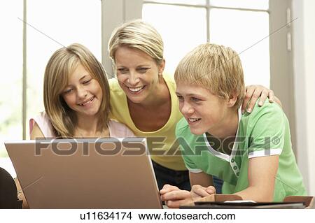 Picture - Mother And Teenage Children Using Laptop At Home. Fotosearch
