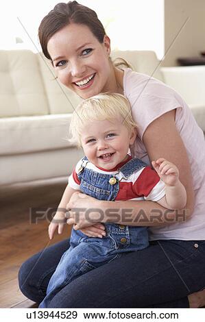 Stock Photo - Mother Cuddling Son At Home. Fotosearch