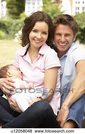 Parents Cuddling Newborn Baby Boy Outdoors At Home View Large Photo Image Stock Photo - Parents Cuddling Newborn Baby Boy Outdoors At Home. Fotosearch