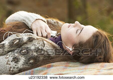 Portrait Of Beautiful Teenage Girl Outdoors Listening To MP3 Player In Autumn Landscape View Large Photo Image Stock Photo - Portrait Of Beautiful Teenage Girl Outdoors Listening To MP3 Player In Autumn Landscape. Fotosearch