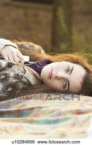 Stock Photograph - Portrait Of Beautiful Teenage Girl Outdoors Listening To MP3 Player In Autumn Landscape. Fotosearch