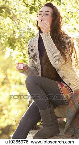 Stock Photograph - Portrait Of Beautiful Teenage Girl Outdoors In Autumn Landscape Blowing Bubbles. Fotosearch