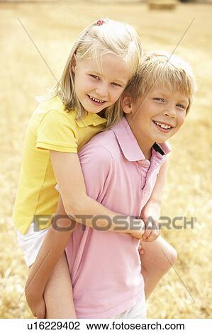 Stock Image - Portrait Of Boy And Girl In Summer Harvested Field. Fotosearch