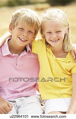 Stock Image - Portrait Of Boy And Girl In Summer Harvested Field. Fotosearch