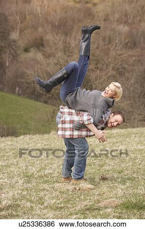 Stock Photograph - Portrait Of Energetic Young Couple Having Fun. Fotosearch