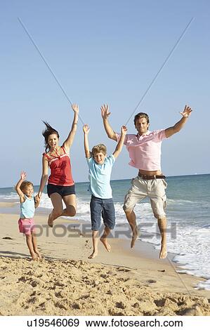 Portrait Of Family On Beach Holiday Jumping In Air View Large Photo Image Stock Photo - Portrait Of Family On Beach Holiday Jumping In Air. Fotosearch