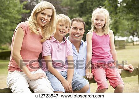 Stock Photo - Portrait Of Family Sitting On Fence In Countryside. Fotosearch