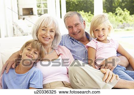 Stock Photography - Portrait Of Grandparents With Grandchildren Relaxing Together On Sofa. Fotosearch