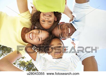 Portrait of Happy Family Looking Down Into Camera In Park View Large Photo Image Stock Photography - Portrait of Happy Family Looking Down Into Camera In Park. Fotosearch