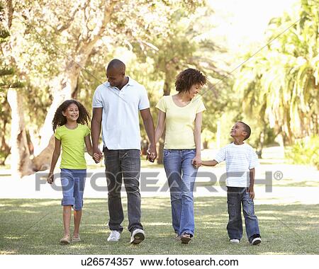 Stock Photo - Portrait of Happy Family Walking In Park. Fotosearch
