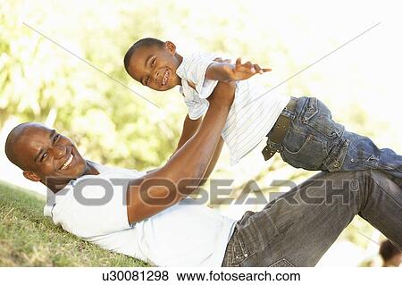 Stock Photo - Portrait of Happy Father and Son In Park. Fotosearch