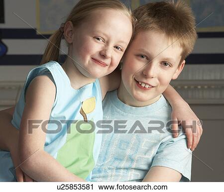 Stock Image - Portrait Of Male And Female Pupils In Classroom. Fotosearch