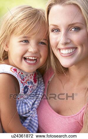 Stock Image - Portrait Of Mother And Child Relaxing In Park. Fotosearch