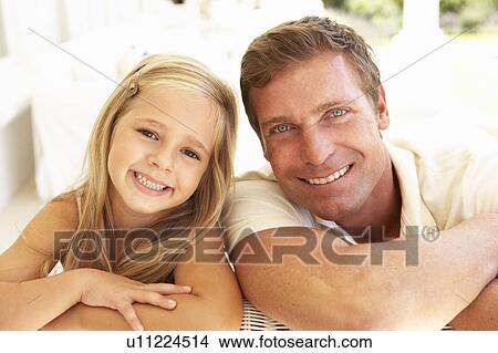 Picture - Portrait Of Mother And Daughter Relaxing Together On Sofa. Fotosearch