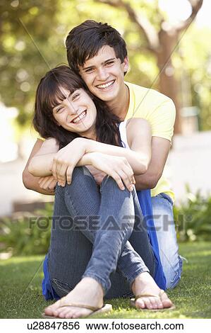 Portrait Of Romantic Teenage Couple Sitting In Park View Large Photo Image Stock Photograph - Portrait Of Romantic Teenage Couple Sitting In Park. Fotosearch