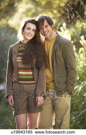Stock Photography - Portrait Of Romantic Young Couple In Autumn Landscape. Fotosearch