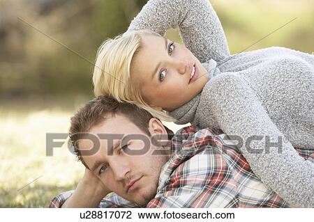 Stock Image - Portrait Of Romantic Young Lying On Grass. Fotosearch