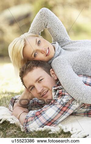 Stock Photograph - Portrait Of Romantic Young Lying On Grass. Fotosearch