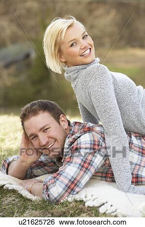 Stock Photograph - Portrait Of Romantic Young Lying On Grass. Fotosearch