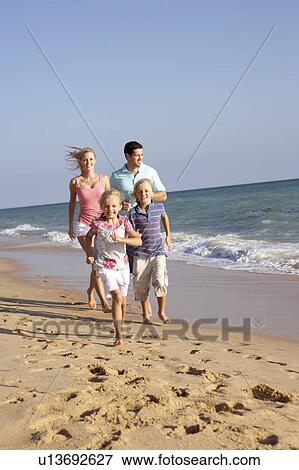 Stock Photo - Portrait Of Running Family On Beach Holiday . Fotosearch