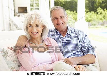 Portrait Of Senior Couple Relaxing Together On Sofa View Large Photo Image Stock Photo - Portrait Of Senior Couple Relaxing Together On Sofa. Fotosearch