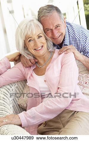 Stock Photo - Portrait Of Senior Couple Relaxing Together On Sofa. Fotosearch