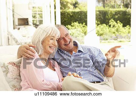 Portrait Of Senior Couple Relaxing Together On Sofa View Large Photo Image Stock Photograph - Portrait Of Senior Couple Relaxing Together On Sofa. Fotosearch
