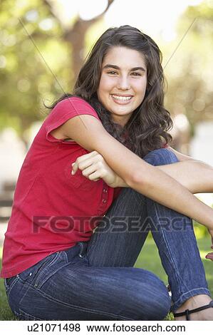 Stock Photo - Portrait Of Teenage Girl Sitting In Park. Fotosearch