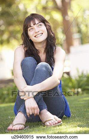 Stock Photography - Portrait Of Teenage Girl Sitting In Park. Fotosearch