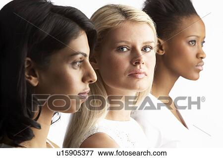 Stock Photo - Portrait Of Three Attractive Young Women In Studio Standing In Line. Fotosearch