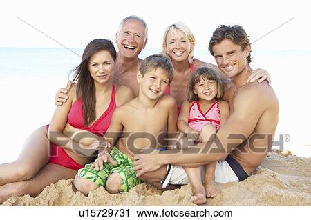 Stock Image - Portrait Of Three Generation Family On Beach Holiday. Fotosearch