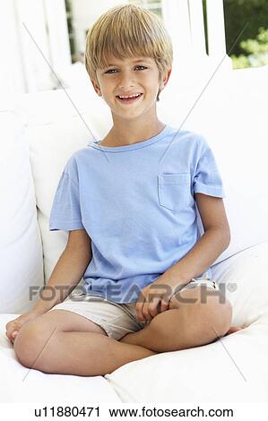 Stock Image - Portrait Of Young Boy Relaxing On Sofa. Fotosearch
