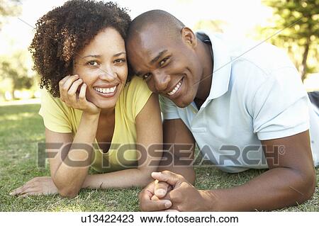 Portrait Of Young Couple Laying On Grass In Park View Large Photo Image Stock Image - Portrait Of Young Couple Laying On Grass In Park. Fotosearch