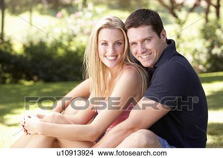 Portrait Of Young Couple Relaxing In Park View Large Photo Image Picture - Portrait Of Young Couple Relaxing In Park. Fotosearch