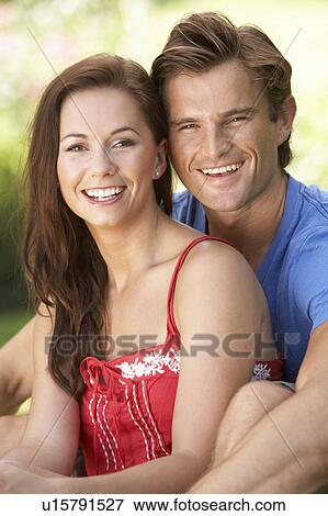 Stock Photo - Portrait Of Young Couple Relaxing In Park. Fotosearch