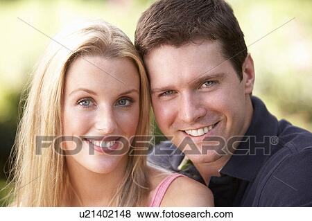Stock Photo - Portrait Of Young Couple Relaxing In Park. Fotosearch