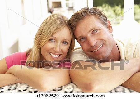 Stock Photo - Portrait Of Young Couple Relaxing Together On Sofa. Fotosearch
