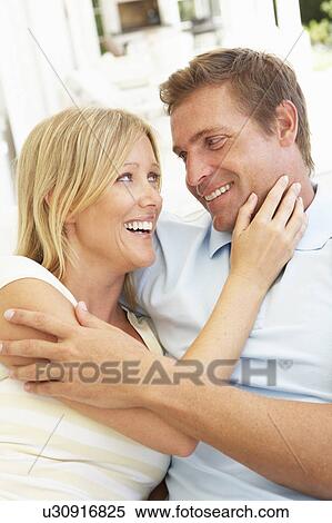 Stock Photography - Portrait Of Young Couple Relaxing Together On Sofa. Fotosearch